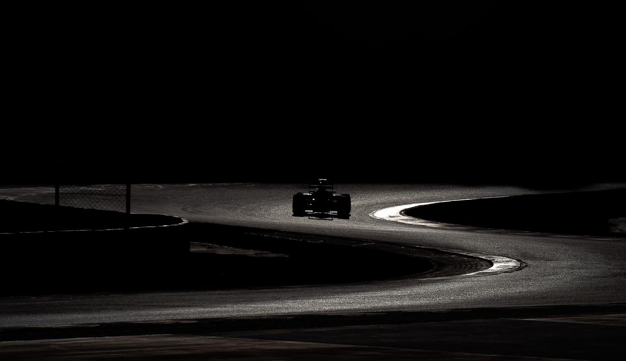 Siluet mobil pebalap Toro Rosso, Max Verstappen, saat beraksi dalam hari ketiga tes pramusim F1 di Sirkuit Catalunya, Barcelona, Spanyol, (3/3/2016). (AFP/Josep Lago)