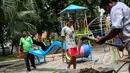 Sejumlah pekerja mengangkat papan perosotan saat proyek pembangunan Ruang Publik Terpadu Ramah Anak (RPTRA) di Jalan Tidore RW 05, Kelurahan Cideng, Gambir, Jakarta, Senin (4/5/2015). (Liputan6.com/Faizal Fanani)