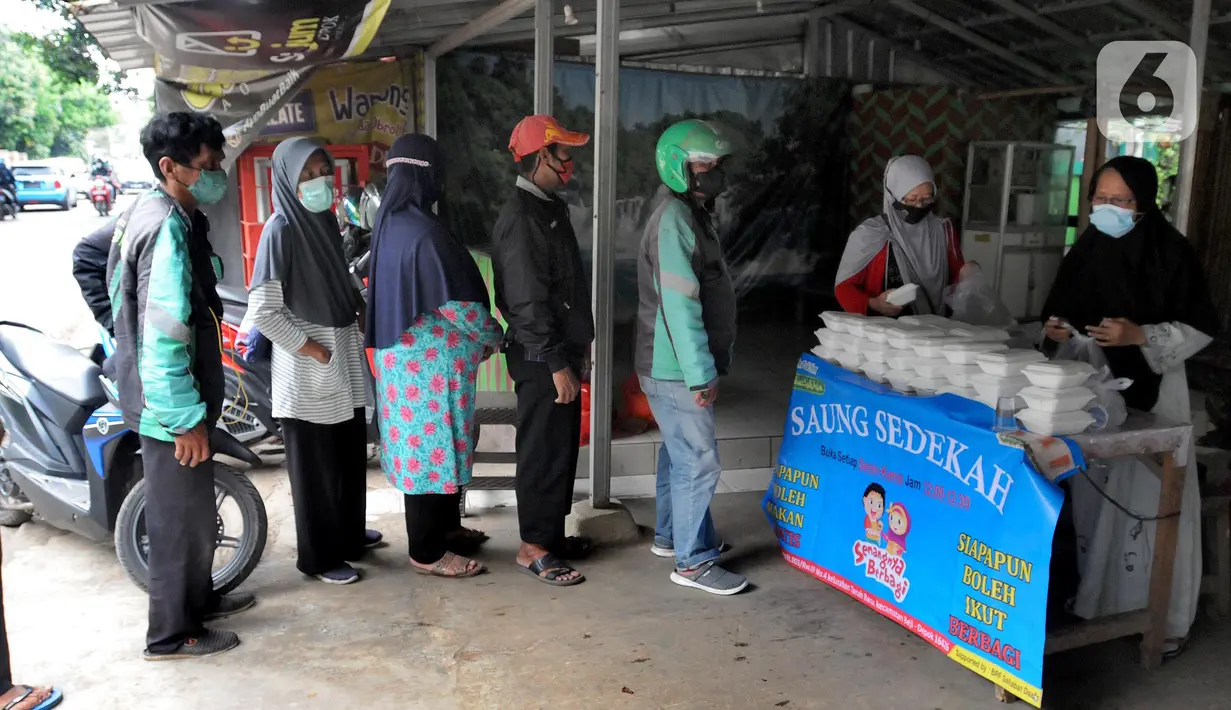 Relawan Yayasan Nasi Jumat (SiJum) Indonesia memberikan  makan siang di Warung Makan Gratis Beji, Depok, Jawa Barat, Rabu (9/3/2022). Makan siang gratis bagi masyarakat umum setiap harinya ini sudah berjalan sejak September 2021. (merdeka.com/Arie Basuki)