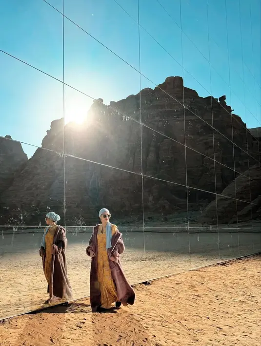 BCL mengenakan sebuah dress panjang berwarna kuning, ditumpuk dengan coat bulu tebal berwarna cokelat. Gayanya disempurnakan dengan turban yang menutupi kepala berwarna biru muda. [Foto: Instagram/itsmebcl]