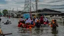 Sejumlah pelajar menggunakan perahu Badan Penanggulangan Bencana Daerah (BPBD) Jakarta untuk melintasi banjir pesisir atau rob di kawasan Muara Angke, Jakarta, Senin (16/12/2024). (merdeka.com/Arie Basuki)