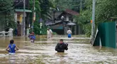 Orang-orang menerobos banjir di Kelaniya, pinggiran Kolombo, Sri Lanka, Senin, 3 Juni 2024. (AP Photo/Eranga Jayawardena)