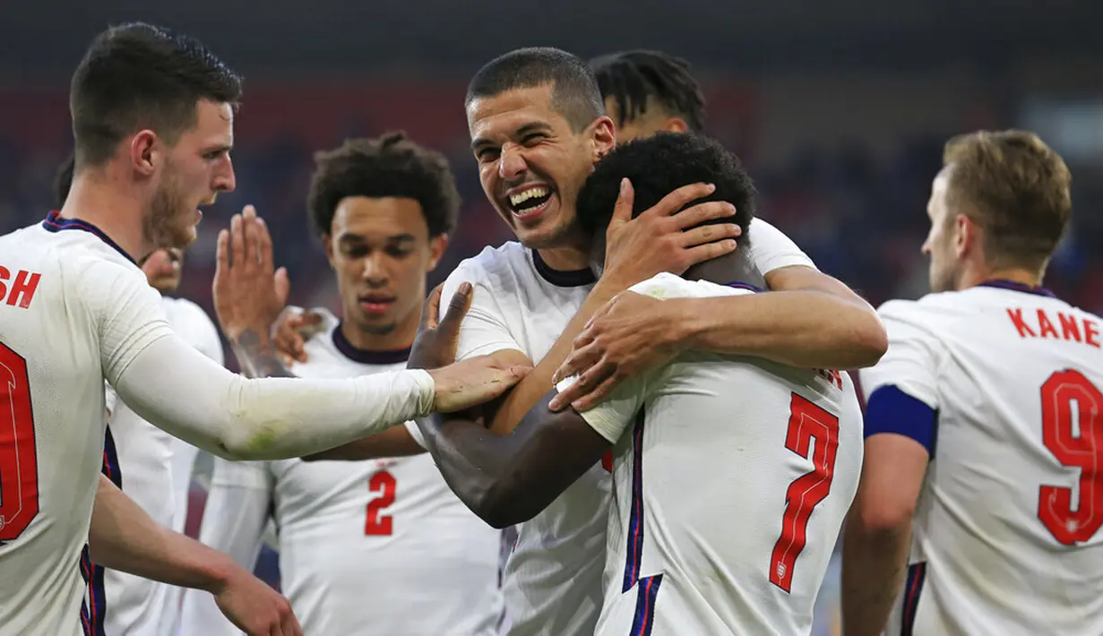 Pemain Inggris Bukayo Saka dipeluk oleh rekannya Conor Coady pada pertandingan persahabatan melawan Austria di Stadion Riverside, Middlesbrough, Inggris, Rabu (2/6/2021). Inggris mengalahkan Austria dengan skor 1-0. (Lindsey Parnaby, Pool via AP)