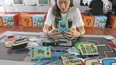 Pengunjung bermain game bot di acara bertajukThe 90s Festival, Jakarta, Sabtu (25/11). Dalam event tersebut terdapat berbagai jenis game, pernak-pernik, makanan, atribut, tokoh super hero, barang-barang generasi tahun 90an. (Liputan6.com/Herman Zakharia)