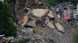 Kendaraan penyelamat bersiaga di jembatan saat tim penyelamat melakukan operasi pencarian dan penyelamatan di lokasi tanah longsor di Kabupaten Pengshui, Chongqing, Tiongkok barat daya, Sabtu, 18 Juli 2026. (AP Photo/Andy Wong)