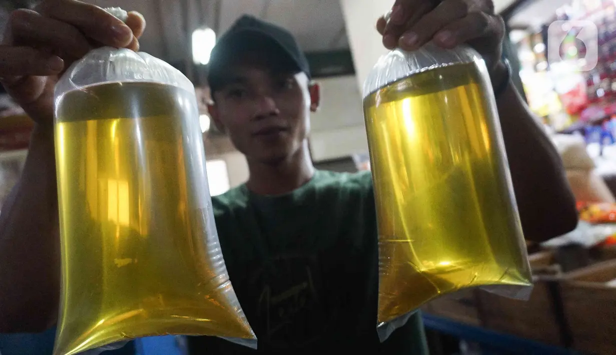 Pedagang menunjukkan plastik berisi minyak goreng curah di Pasar Senen, Jakarta, Selasa (31/5/2022). Kementerian Perindustrian mencabut subsidi minyak goreng curah kepada pelaku usaha mulai Selasa (31/5/2022). (Liputan6.com/Herman Zakharia)