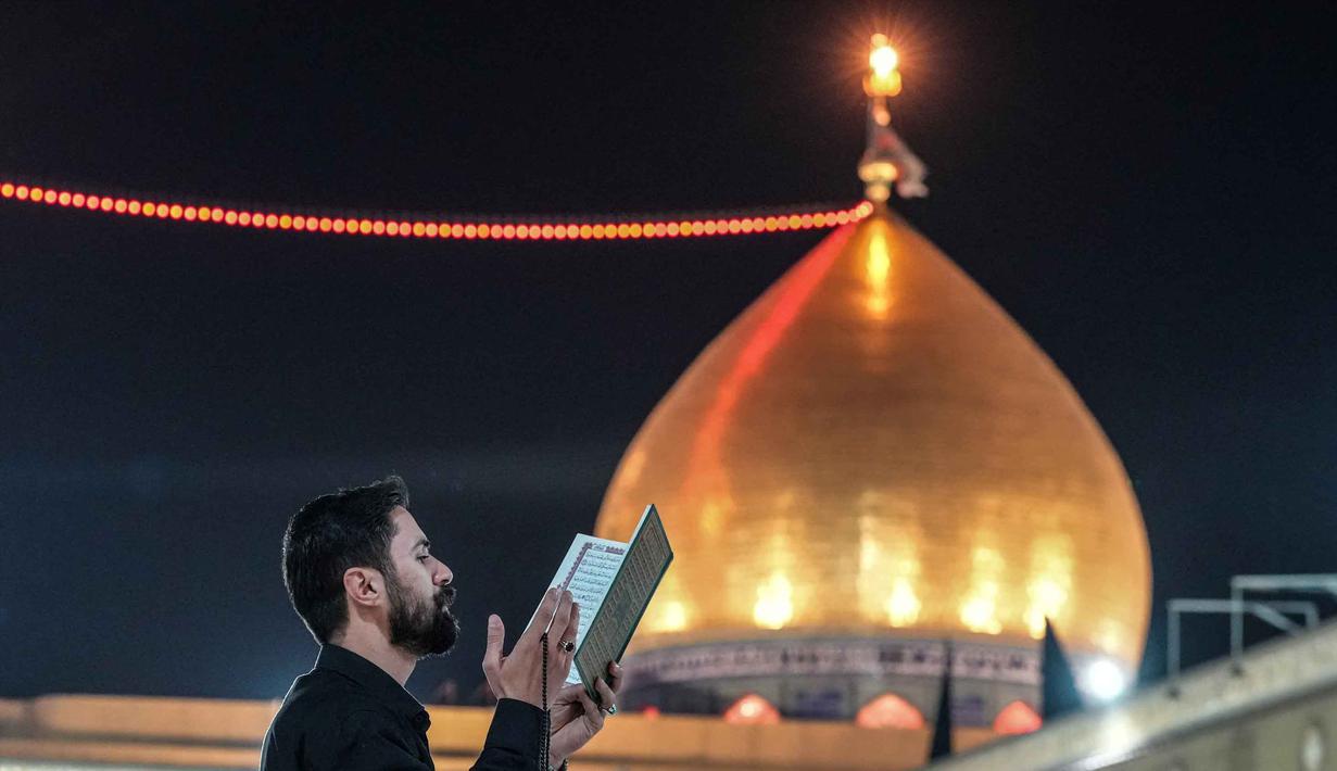 Seorang Muslim Syiah membaca Al-Quran, saat melaksanakan Itikaf di Masjid Kufa, selatan Baghdad, Irak, pada 12 Maret 2026. (Qassem al-KAABI/AFP)