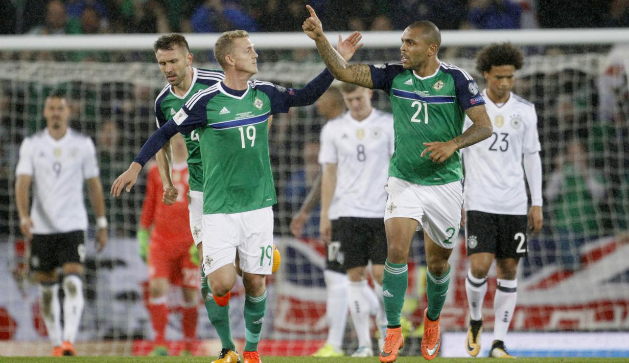 Pemain Irlandia Utara, Josh Magennis dan George Saville melakukan selebrasi usai cetak gol ke gawang Jerman pada laga Kualifikasi Piala Dunia 2018 di Stadion Windsor Park, Kamis (5/10/2017). Jerman menang 3-1 atas Irlandia Utara. (AP/Peter Morrison)