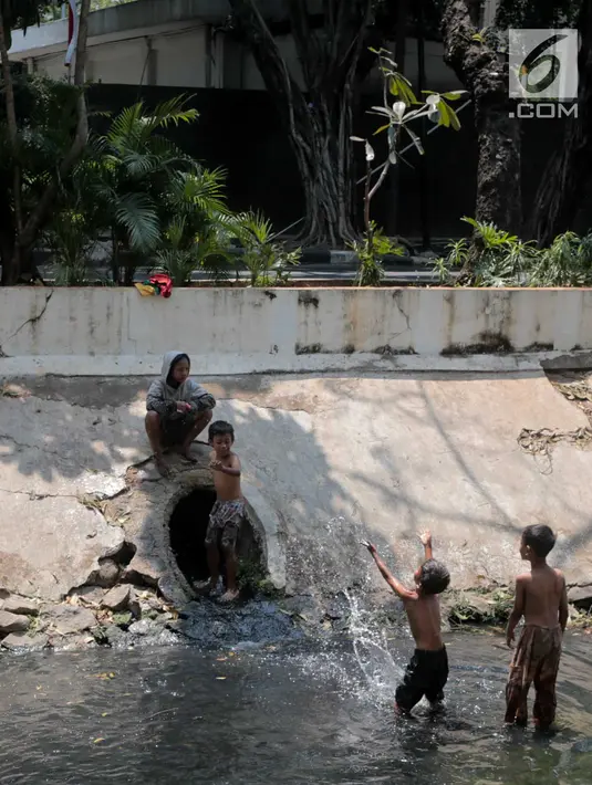 Sejumlah anak-anak bermain di kali menteng, Jakarta, Selasa (20/8/2019). Kurangnya lahan bermain membuat mereka terpaksa memanfaatkan kali menteng yang kotor sebagai tempat bermain. (Liputan6.com/Faizal Fanani)