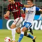 Penyerang AC Milan, Fabio Borini berusaha membawa bola dari kawalan pemain U Craiova, Alexandru Mateiu saat bertanding di leg kedua babak 3 Liga Europa di San Siro, Milan, (3/8). AC Milan sukses menang 2-0 atas Craiova. (AP Photo/Antonio Calanni)