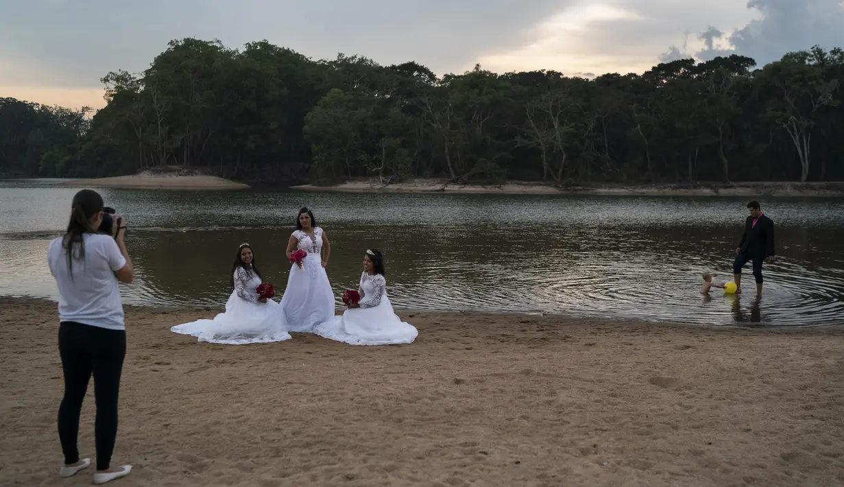 Eliene Pereira Francisco (tengah) berpose untuk foto untuk album pernikahan dengan putrinya Jaiane Pereira Marsal (kiri) dan Gislaine Pereira de Araujo dengan latar belakang hutan hujan Amazon di pantai sungai Jamanxim di Novo Progresso, Brasil (2/9/2019). (AP Photo/Leo Correa)