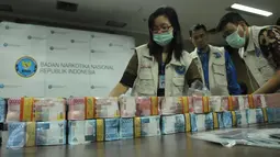 Uang senilai 17 milyar hasil kejahatan narkotika ditampilkan saat rilis di di kantor BNN, Jakarta, Jumat (28/4). Jumlah tersebut merupakan gabungan dari tiga kasus narkotika yang diungkap sejak awal 2017. (Liputan6.com/Helmi Afandi)