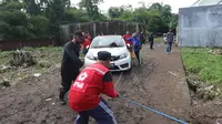 Anggota PMI bersama tim relawan membantu mengevakuasi mobil milik warga Teluk Bayur, Kota Malang, usai terendam dampak banjir besar pada Senin, 14 Maret 2022 (Liputan6.com/Zainul Arifin)