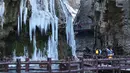 Sejumlah pengunjung menikmati pemandangan air terjun beku di objek wisata Gunung Yuntai di Jiaozuo, Provinsi Henan, China tengah, pada 24 Desember 2020. (Xinhua/Xu Yanan)
