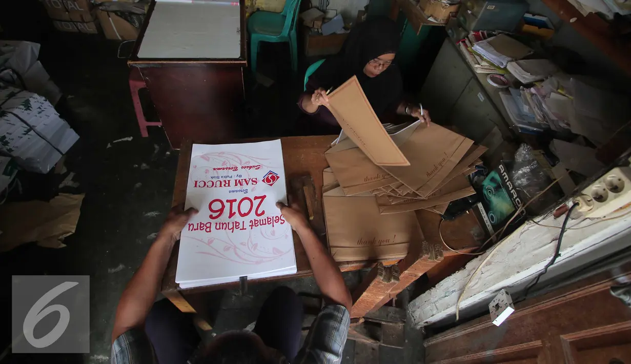 Pekerja merapihkan tahapan akhir pembuatan kalender 2016 di Jakarta, Rabu (25/11). Jelang taun 2016 permintaan pemesanan kalender meningkat sebesar 100%, mayoritas pemesanan berasal dari perkantoran dan hotel. (Liputan6.com/Angga Yunuar)