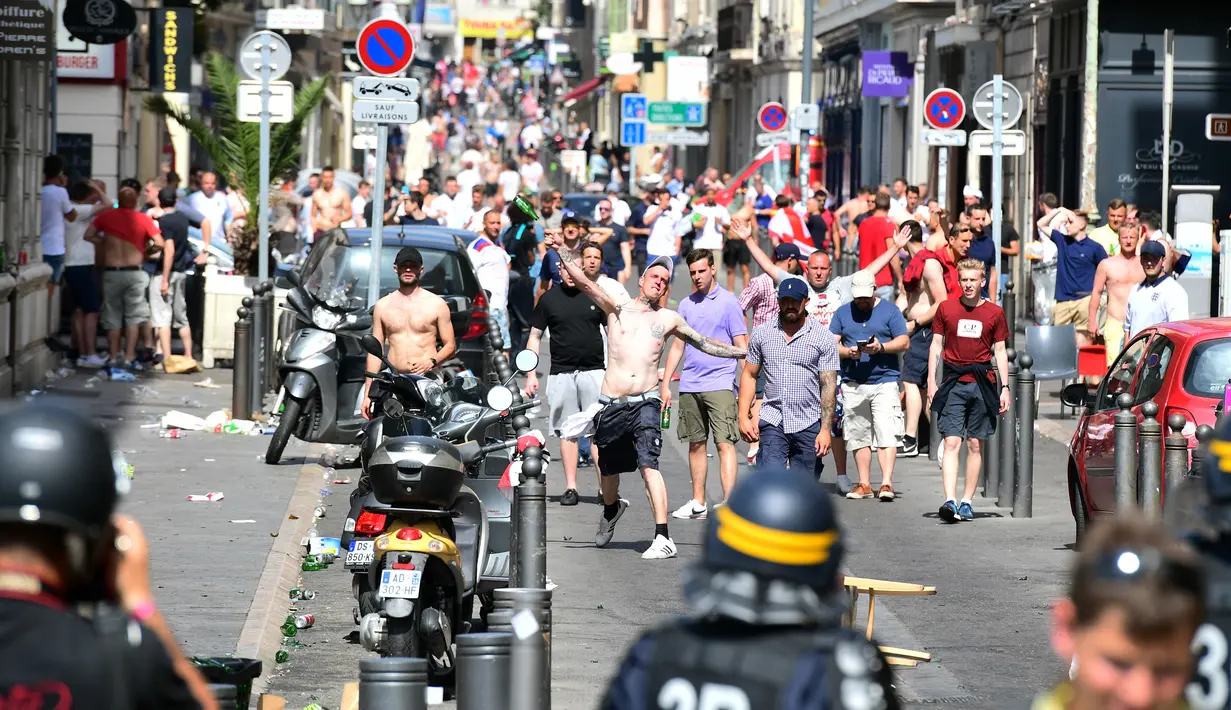 Fans Inggris melempari polisi dengan botol saat bentrok terjadi di kota Marseille, Prancis (11/6/2016).  (AFP Photo/ Leon Neal) 