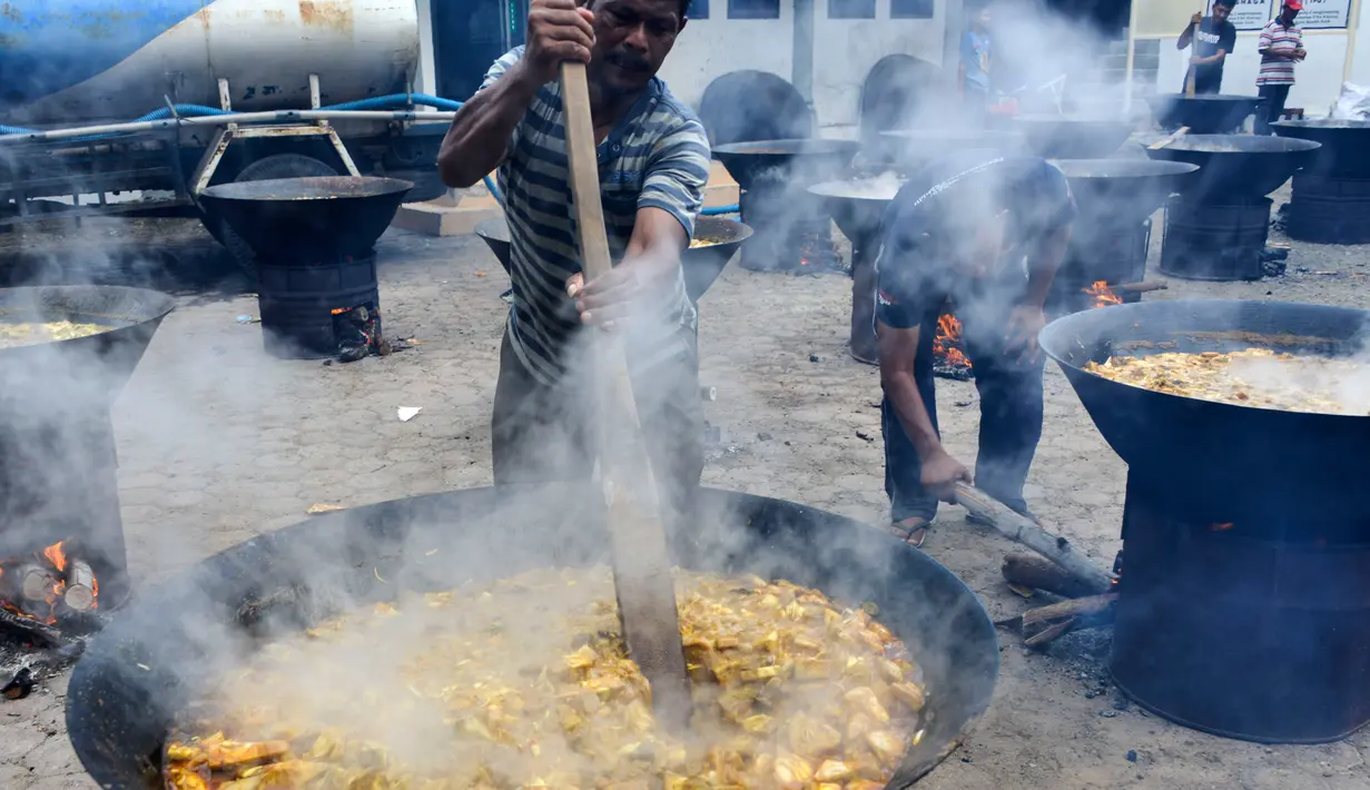 Para pria memasak kari tradisional sebelum umat muslim berbuka puasa di sebuah masjid di Banda Aceh pada 26 Mei 2019. Menu ini sering dimasak setiap memperingati kenduri Nuzul Quran pada setiap pertengahan bulan suci Ramadan. (Photo by CHAIDEER MAHYUDDIN / AFP)