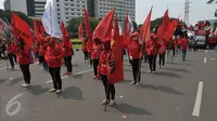Sejumlah wanita membawa bendera saat aksi Hari Buruh di Jakarta, Senin (1/5). Dalam aksinya para buruh meminta sistem kerja kontrak dan upah rendah dihapus. (Liputan6.com/Helmi Afandi)