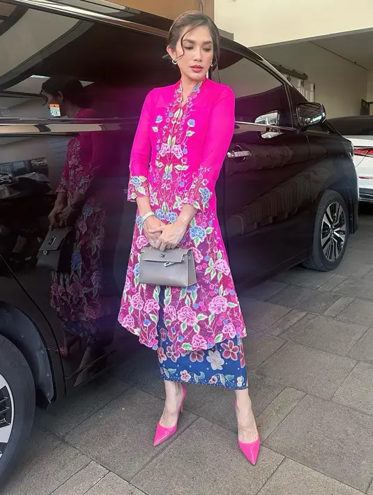 Ussy Sulistyawati tampil feminin etnik dengan kebaya panjang fuschia dan kain batik biru [@ussypratama]