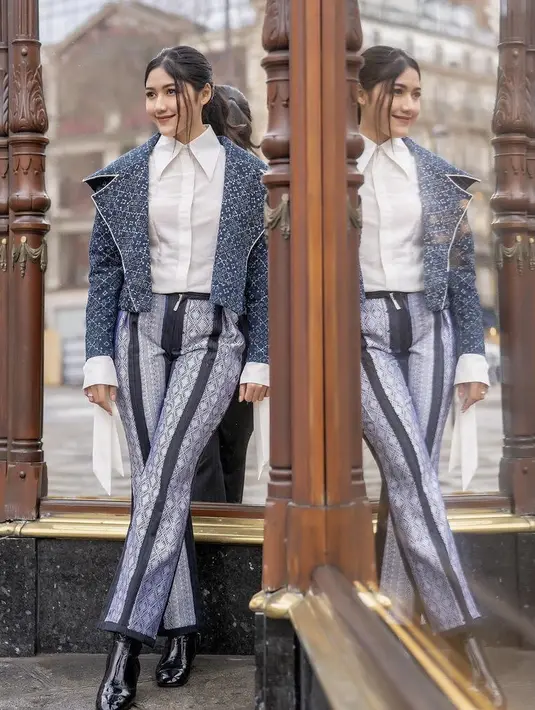 Blazer tersebut dipadukan dengan celana yang dibuat dari kain songket Halaban Sumatera Barat. Celana tersebut pun dirancang oleh Wilsen Willim. Tampilan semakin gaya dengan sepatu boots hitamnya. Credit: Instagram/(@erinagudono)