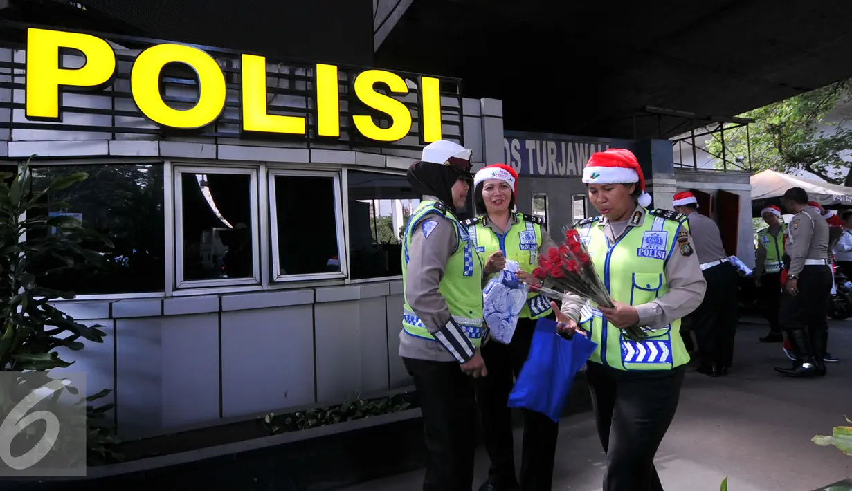 Petugas Kepolisian bersama sinterklas bersiap membagikan bunga dan masker di jalan kawasan Tomang, Jakarta, Rabu (23/12). Menyambut Hari Natal 2015, anggota Kepolisian Polres Jakarta Barat kenakan topi Sinterklas. (Liputan6.com/Yoppy Renato)