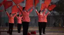 Kelompok Serikat Wanita Sosialis mengibarkan bendera saat melakukan propaganda di depan Hotel Ryugyong, Pyongyang, Korea Utara, Sabtu (9/3). Semua wanita Korea Utara yang tidak bekerja adalah anggota Serikat Wanita Sosialis. (Ed Jones/AFP)