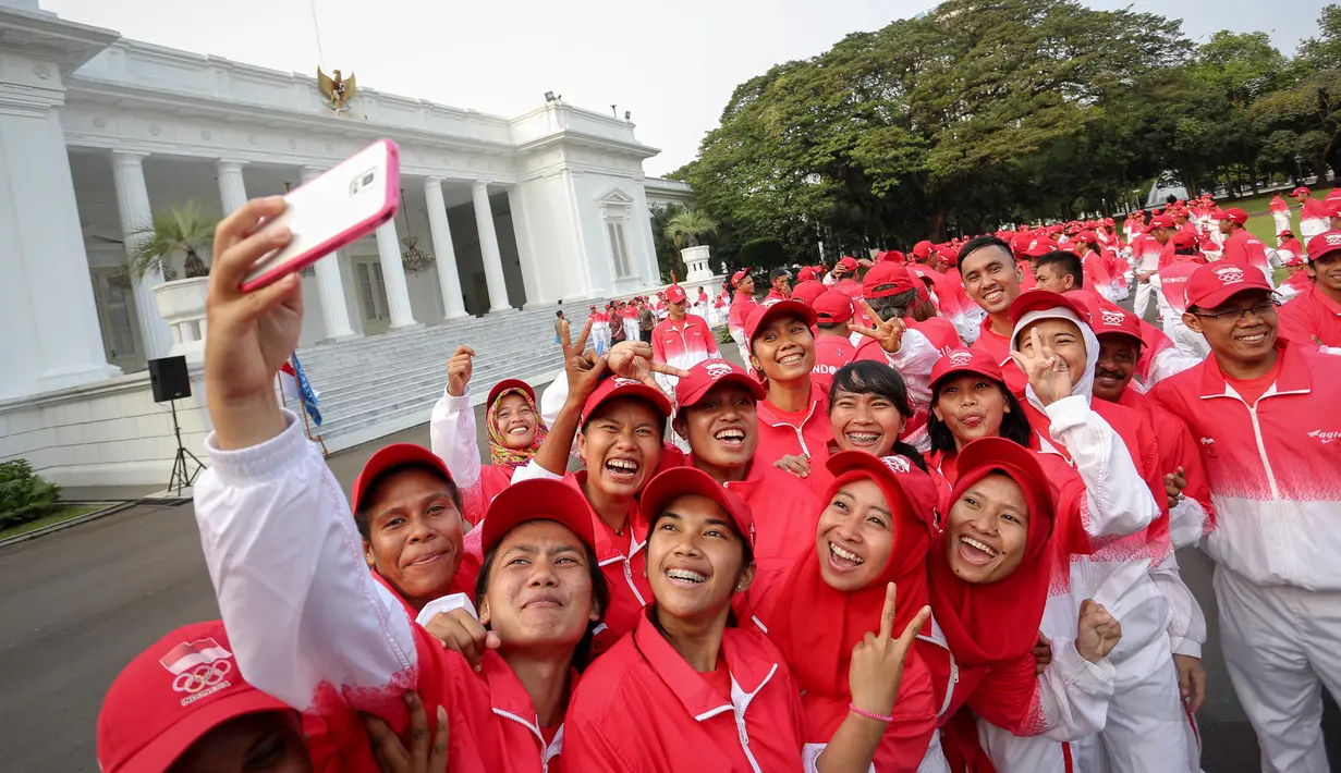 Sejumlah atlet berselfie saat berada di depan Istana Merdeka sebelum acara pelepasan kontingen sea games di Istana Merdeka, Jakarta, Selasa (26/5/2015). Indonesia menurunkan 522 atlet yang berlaga di 32 cabang olah raga. (Liputan6.com/Faizal Fanani)