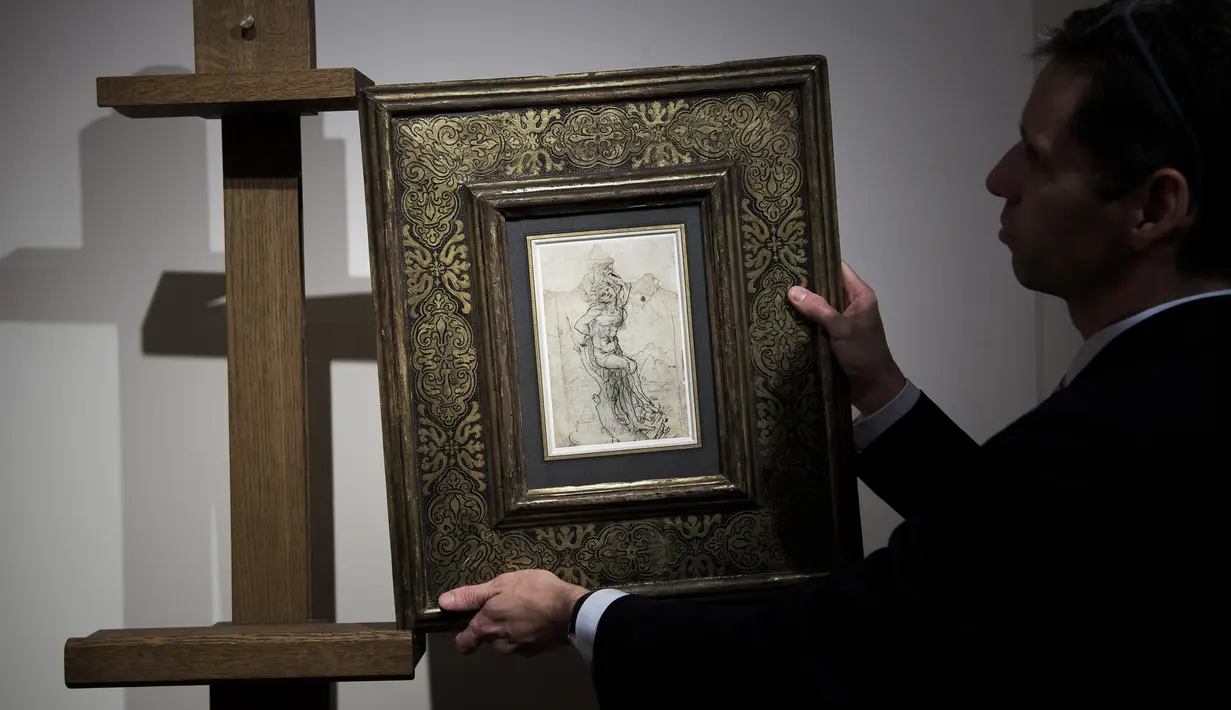 Seorang anggota Rumah Lelang Tajan menyiapkan gambar sketsa karya Leonardo da Vinci sebelum dilelang di Paris, Prancis (13/12). Leonardo da Vinci adalah seorang seniman yang dikenal dengan lukisan 'Mona Lisa'. (AFP/Philippe Lopez)