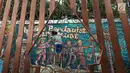 Seorang pria menyelesaikan pembuatan lukisan mural di Kawasan TBRS Semarang, Minggu, (3/3). Acara yang diadakan oleh KPU Jateng ini adalah sosialisasi ajakan mencoblos pemilu saat april mendatang. (Liputan6.com/Gholib)
