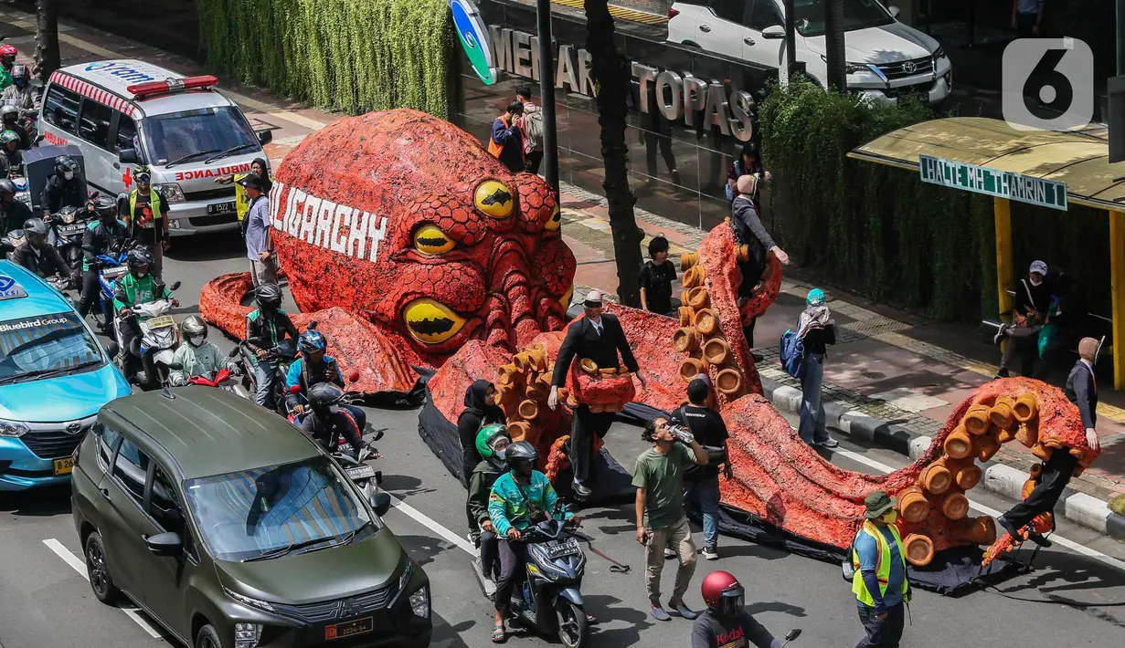 Peserta aksi juga mengarak boneka gurita raksasa sebagai simbolisasi mengguritanya bisnis para oligarki (Liputan6.com/Angga Yuniar)