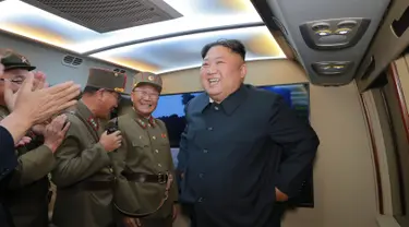 Pemimpin Korut Kim Jong-Un tersenyum setelah mengamati tembakan dua rudal taktis terbaru di lokasi bagian barat yang dirahasiakan (7/8/2019). Peluncuran rudal terbaru negaranya, adalah peringatan keras bagi Washington dan Seoul atas rencana latihan militer kedua negara. (KCNA VIA KNS/AFP)