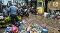 Warga beres-beres usai banjir di Kebalen, Jakarta, Minggu (21/2/2021). Banjir yang terjadi kemarin karena curah hujan yang tinggi meninggalkan sampah di rumah warga. (Liputan6.com/Johan Tallo)