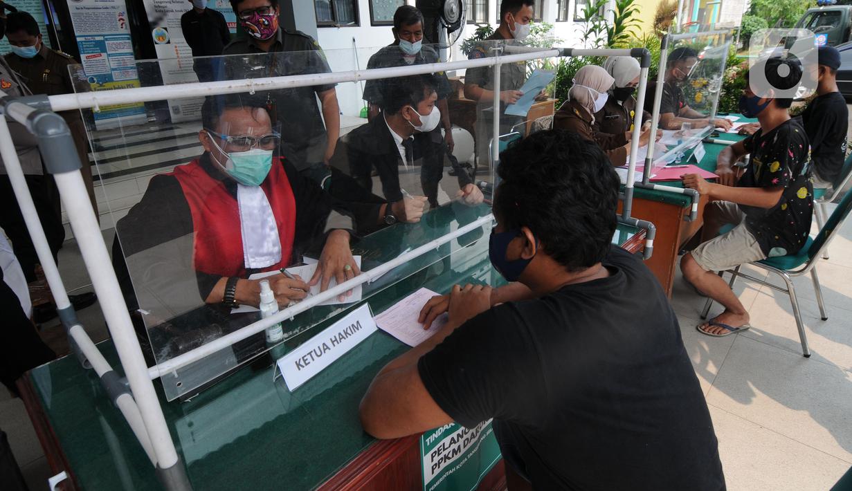 Hakim berbicara kepada pelanggar saat Sidang Tipiring pelanggaran PPKM Darurat di kantor Kecamatan Pamulang, Tangerang Selatan, Banten, Senin (19/7/2021). Dua puluh empat pelanggar diantaranya tidak bermasker dan jam operasional tempat usaha didenda. (merdeka.com/Arie Basuki)