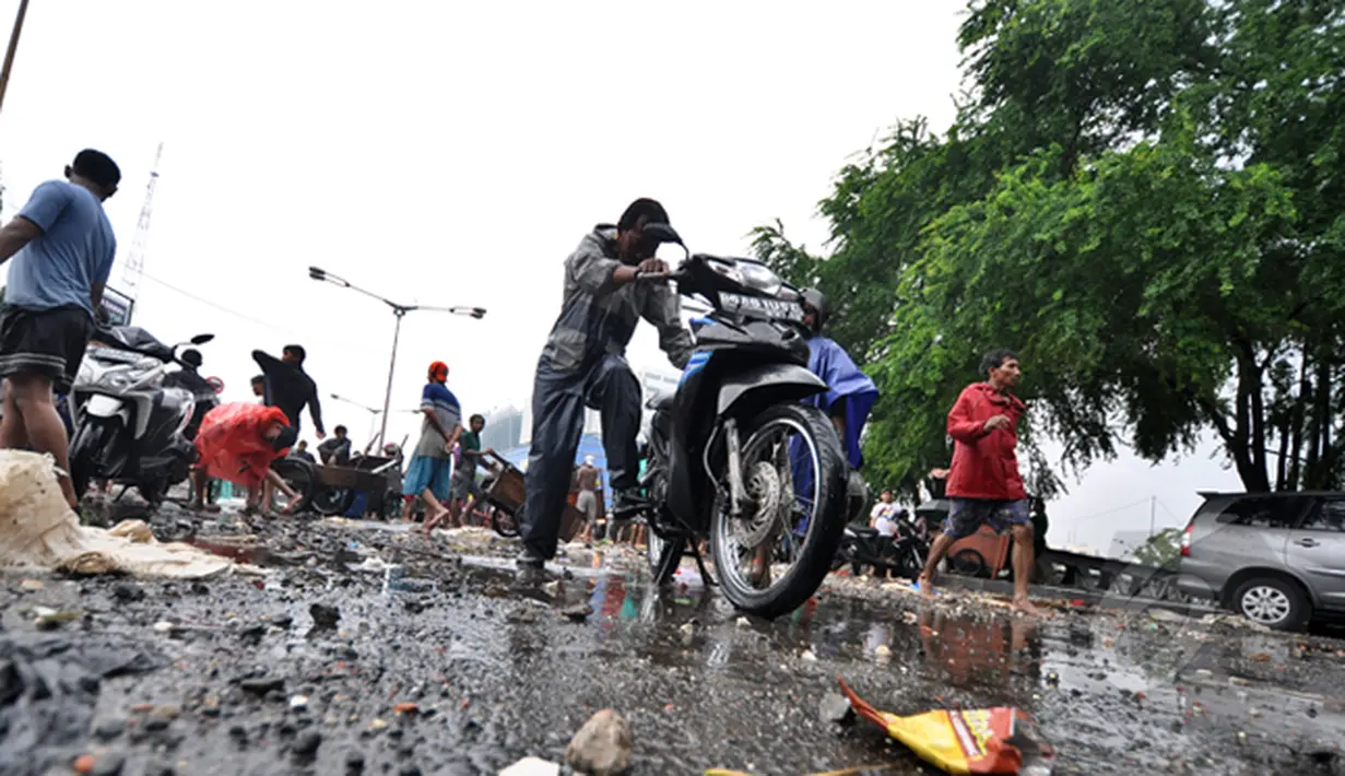 Seorang bapak berusaha menyalakan motornya yang mati akibat melewati banjir, Jakarta, Senin (6/2/2015).  Hujan yang turun sejak malam hingga kini membuat sejumlah ruas jalan tergenang air. (Liputan6.com/Faizal Fanani)