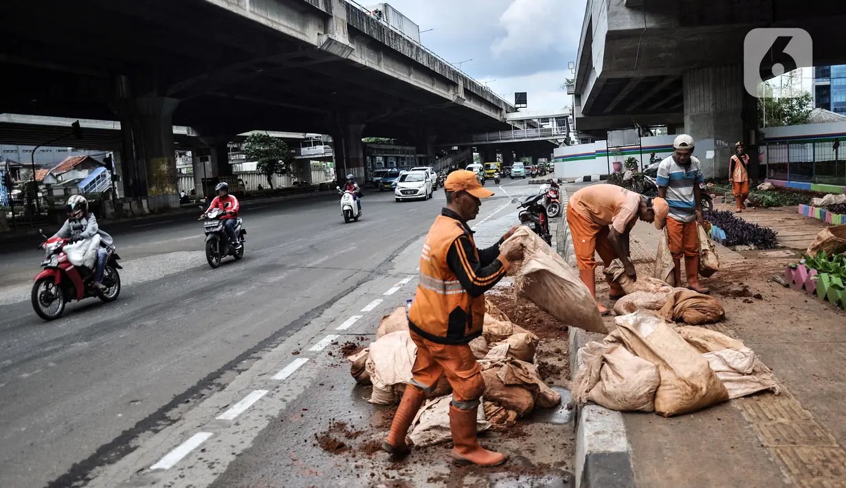 Petugas penanganan prasarana dan sarana umum (PPSU) Kelurahan Cipinang Besar Selatan saat menyelesaikan pembuatan taman di Jalan DI Panjaitan, Jakarta Timur, Rabu (14/12/2022). Aturan pembatasan usia maksimal Penyedia Jasa Lainnya Perorangan (PJLP) DKI Jakarta tertuang dalam Keputusan Gubernur (Kepgub) Nomor 1095 Tahun 2022 tentang Pedoman Pengendalian Penggunaan Penyedia Jasa Lainnya Perorangan di Lingkungan Pemerintah Provinsi Daerah Khusus Ibu Kota Jakarta. (merdeka.com/Iqbal S. Nugroho)