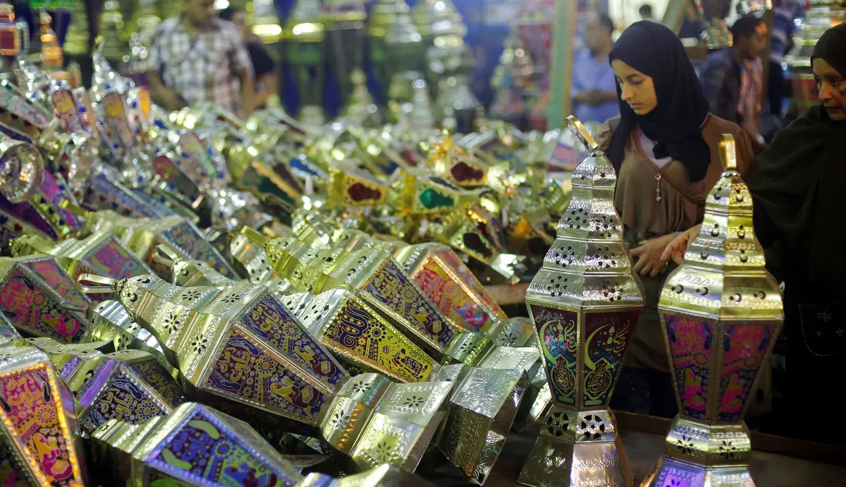 Calon pembeli saat melihat - lihat kios yang berjualan lentera khas Ramadan dan beraneka lampu di pasar Sayida Zienab, Mesir 6 Juni 2016. Biasanya orang mesir menyebut lentera tersebut dengan nama " Fanoos Ramadan ". (REUTERS / Amr Abdallah Dalsh)