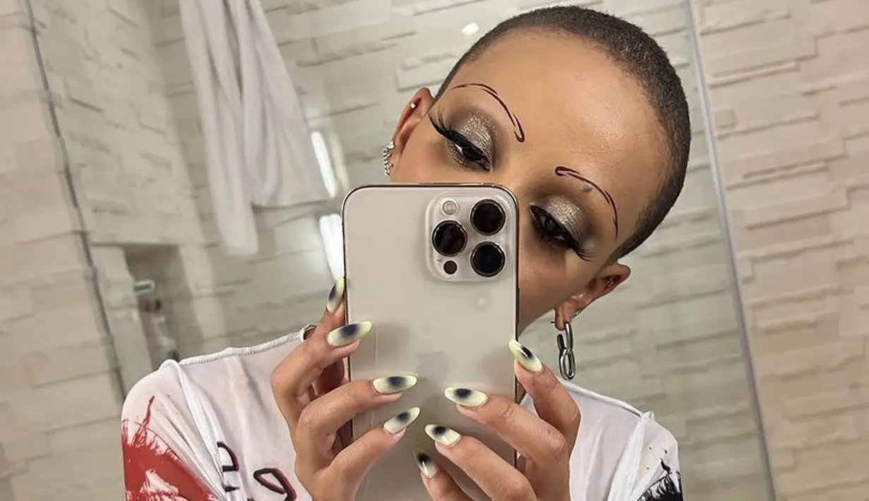 <p>Dengan eyeshadow shimmernya, Doja Cat juga memerlihaykan alis mata abstraknya. Ditambah bulu mata yang lentik di ujungnya.@dojacat</p>