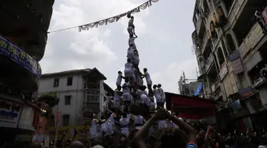 Umat Hindu membentuk piramida manusia untuk mencapai dan memecahkan dahi-handi (pot yang terbuat dari tanah liat) selama Festival Janmashtami di Mumbai, India pada 24 Agustus 2019. Festival ini menandai kelahiran dewa Krishna. (AP Photo/Rajanish Kakade)