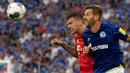 Bek Bayern Munchen, Lucas Hernandez, duel udara dengan striker Schalke, Guido Burgstaller, pada laga Bundesliga di Veltins-Arena, Gelsenkirchen, Sabtu (24/8). Schalke kalah 0-3 dari Munchen. (AFP/Federico Gabarini)