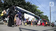 Penumpang menyeberang jalan setibanya di Terminal Kampung Rambutan, Jakarta TImur, Jakarta, Minggu (8/5/2022). Terminal Kampung Rambutan telah melewati puncak arus balik Lebaran 2022, yakni pada H+4. (Liputan6.com/Faizal Fanani)