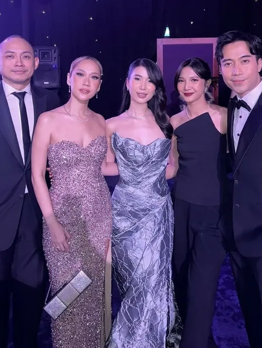 Bunga Citra Lestari mengenakan tube dress shimmer berpayet warna pink dipadukan kalung silver serasi dengan hand bagnya. Christie mengenakan tube dress bertekstur warna silver. [@christie]