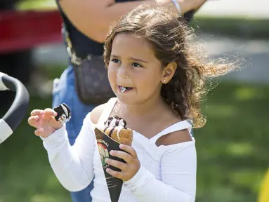 Seorang anak perempuan menikmati es krimnya saat Festival Es Krim Toronto di Toronto, Kanada, Sabtu (15/8/2020). Festival Es Krim Toronto diadakan pada 15-16 Agustus 2020 di tengah pandemi COVID-19. (Xinhua/Zou Zheng)