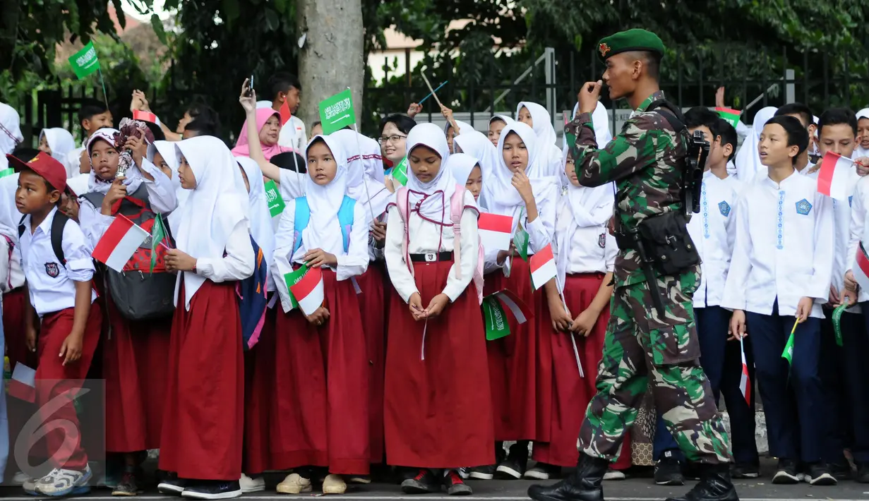 Personel TNI AD menjaga barisan pelajar yang menyambut kedatangan Raja Salman bin Abdulaziz di sekitar Istana Bogor, Rabu (1/3). 21 dentuman meriam dan kibaran bendera kedua negara mewarnai sambut Raja Salman. (Liputan6.com/Helmi Fithriansyah)