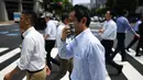 Seorang pria menyeka wajahnya saat berjalan selama gelombang panas melanda Tokyo, Jepang (1/8/2019). Badan Meteorologi Jepang (JMA) mencatat suhu tertinggi Tokyo mencapai 35,4 derajat celcius. (AFP Photo/Charly Triballeau)