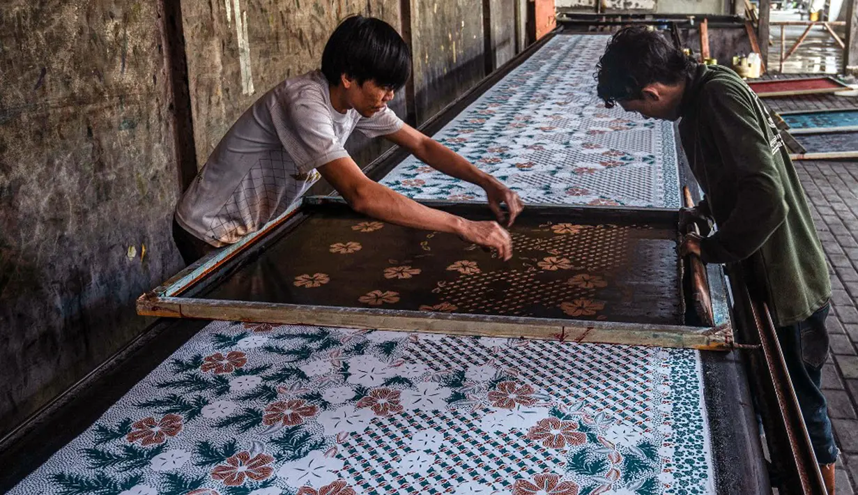 Para pekerja membuat batik sablon di Sidoarjo, Jawa Timur, Sabtu (1/10/2022). Indonesia akan memperingati Hari Batik Nasional pada 2 Oktober. (JUNI KRISWANTO/AFP)