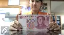<p>Seorang teller menunjukan mata uang Yuan di Jakarta, Senin (30/11). Dana Moneter Internasional (IMF), Senin (30/11), resmi memasukan yuan, atau renminbi, ke dalam special drawing rights (SDR) sebagai mata uang elite dunia. (Liputan6.com/Angga Yuniar)</p>