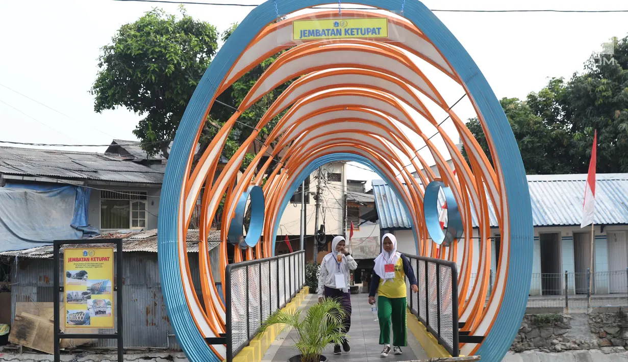 Dua pelajar melintasi Jembatan Ketupat di Jalan Gajah Mada, Petojo, Jakarta, Kamis (8/8/2019). Jembatan Ketupat memiliki bentang 12,5 meter dan lebar 2,5 meter dengan waktu pengerjaan selama 45 hari. (Liputan6.com/Helmi Fithriansyah)