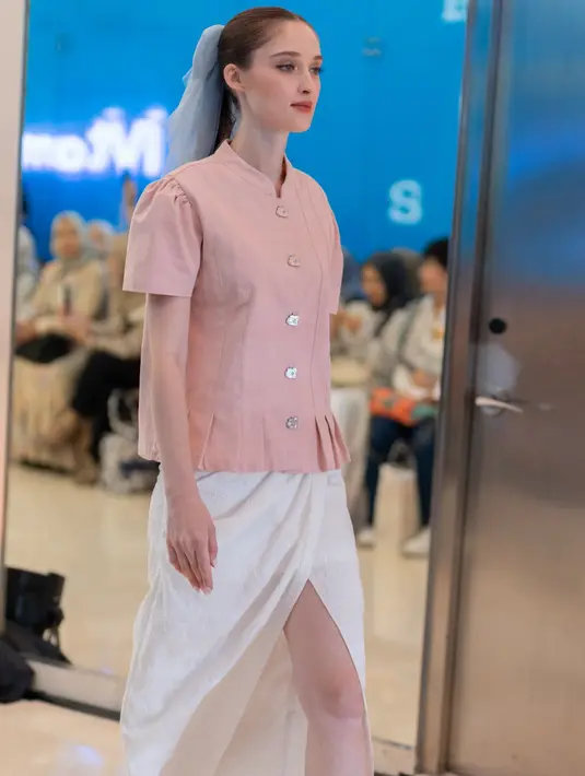 Tampil lebih kasual feminin dengan atasan lengan pendek pink dipadukan rok slit putih. [dok. Plaza Indonesia]