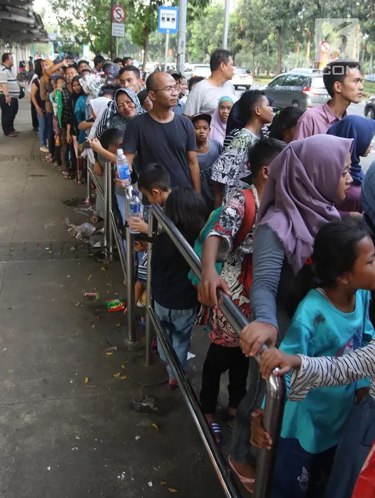 Warga antre untuk menaiki bus tingkat wisata keliling Ibu Kota di kawasan Monas, Jakarta, Sabtu (16/6). Libur Hari Raya Idul Fitri dimanfaatkan oleh sebagian masyarakat Jakarta untuk berlibur ketempat wisata bersama keluarga. (Liputan6.com/Arya Manggala)