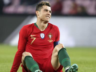 Bintang Portugal, Cristiano Ronaldo, tampak kesakitan saat melawan Belanda pada laga persahabatan di Stade de Geneve, Swiss, Senin (26/3/2018). Portugal kalah 0-3 dari Belanda. (AP/Salvatore Di Nolfi)